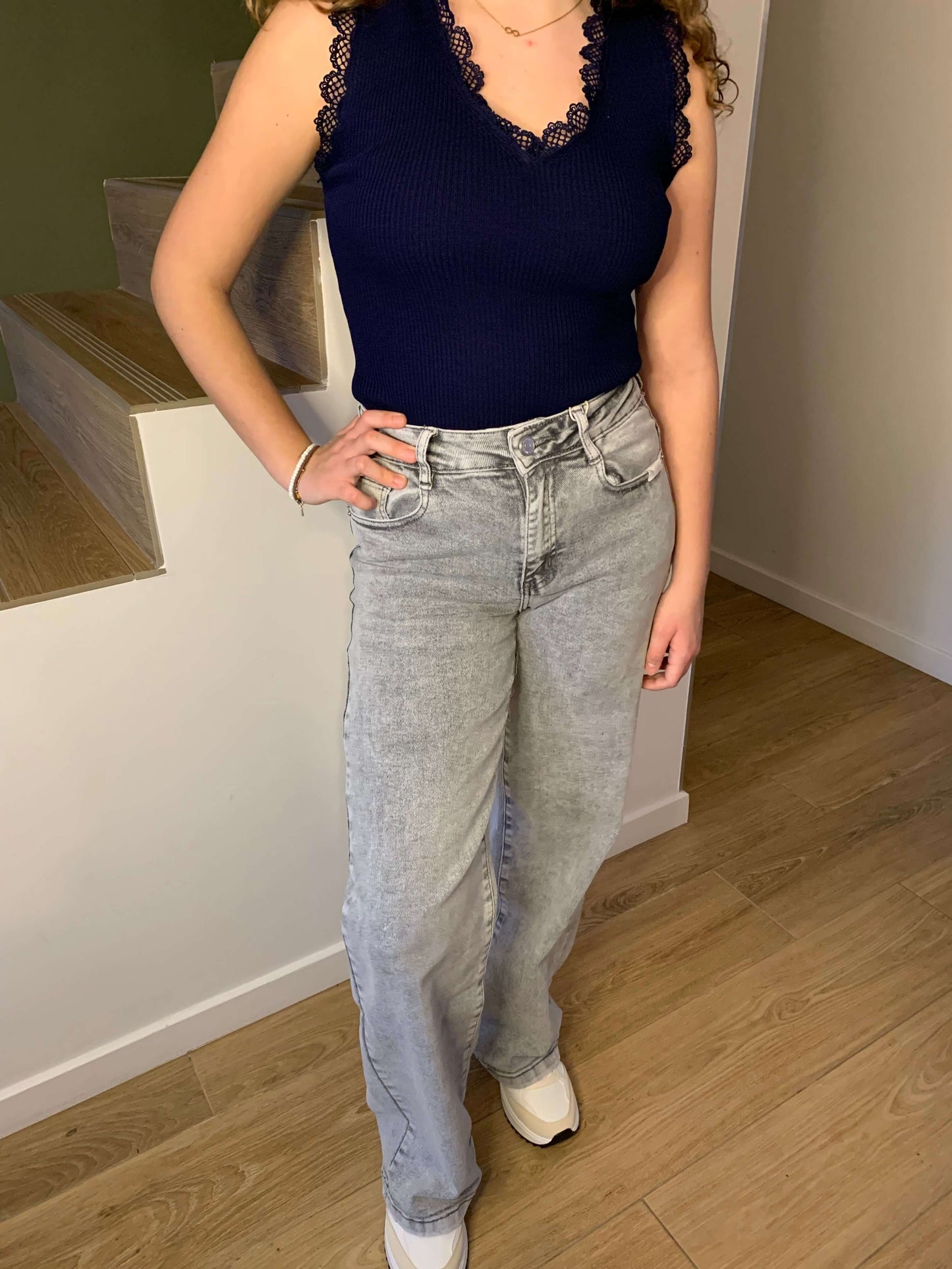 Jean wide leg gris clair Luna Chic porté avec un top marine sans manches, coupe flatteuse et tendance décontractée