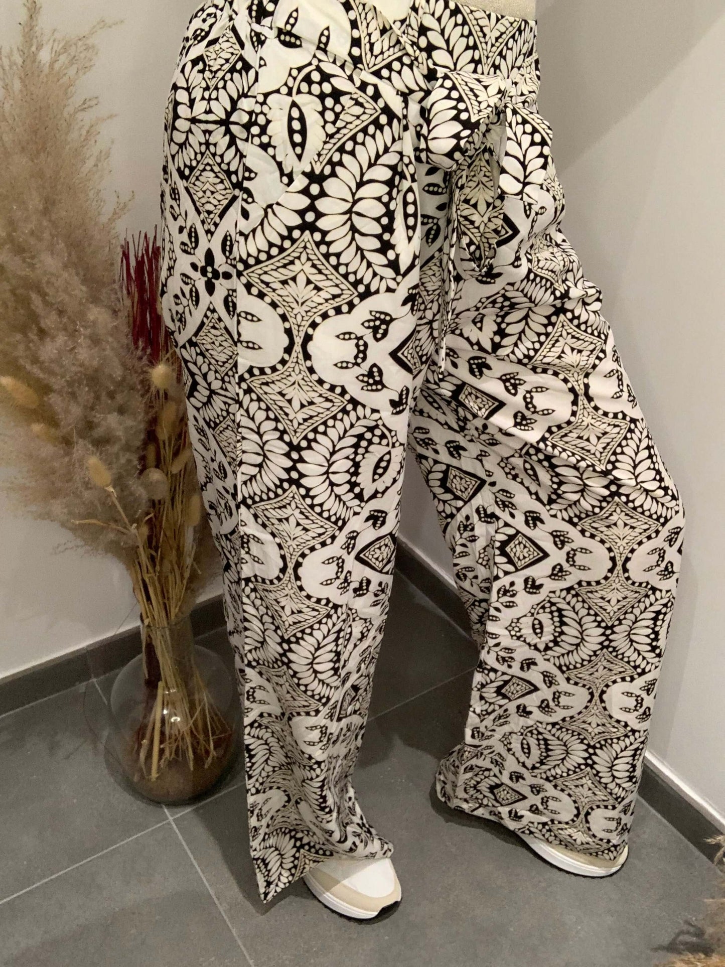 Pantalon fluide Luna Chic porté de côté avec imprimé noir et blanc et ceinture nouée en détail