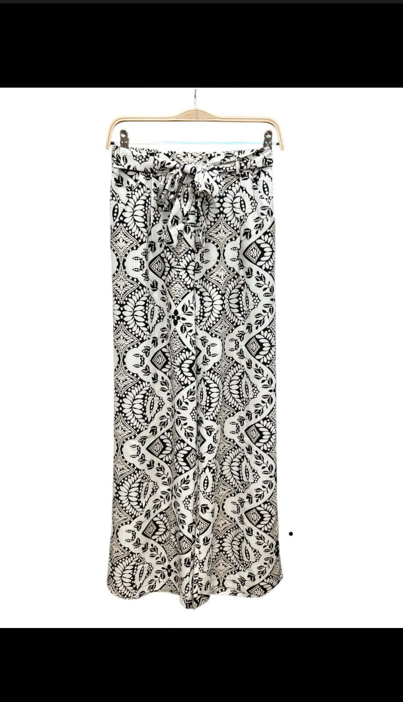 Pantalon fluide noir et blanc Luna Chic vu à plat sur cintre – coupe large, taille haute élastique et ceinture nouée