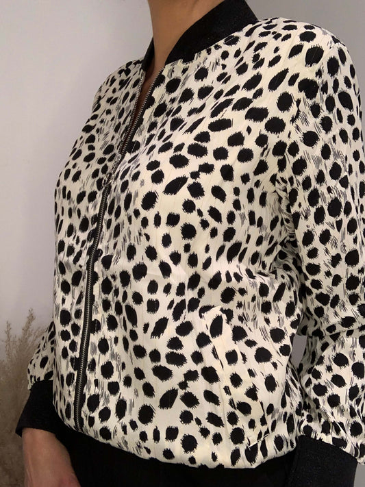 Bomber femme léopard noir et blanc vu de profil – détails zip argenté et col côtelé noir